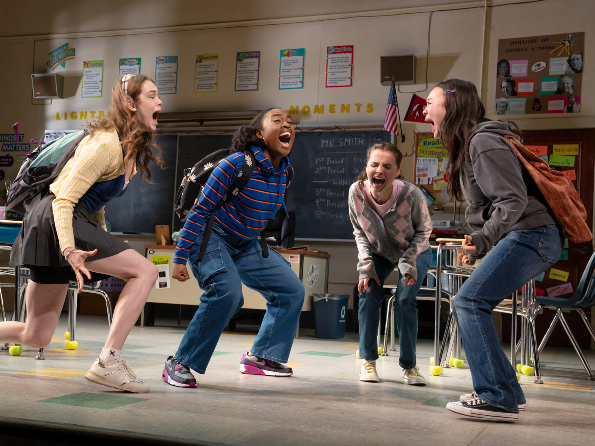 girls in a classroom stand in a circle screaming